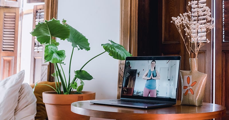 Laptop on a table showing an online yoga class